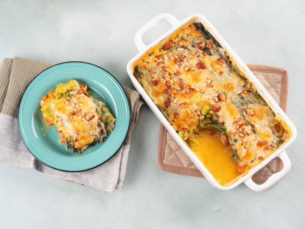 Süßkartoffel-Kohl-Auflauf mit einer Portion auf einem Teller.