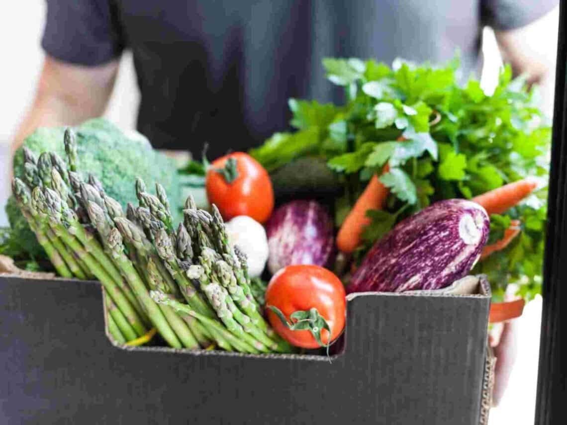 Mann trägt eine regionale Biokiste.