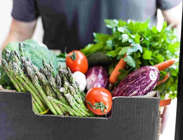 Mann trägt eine regionale Biokiste.