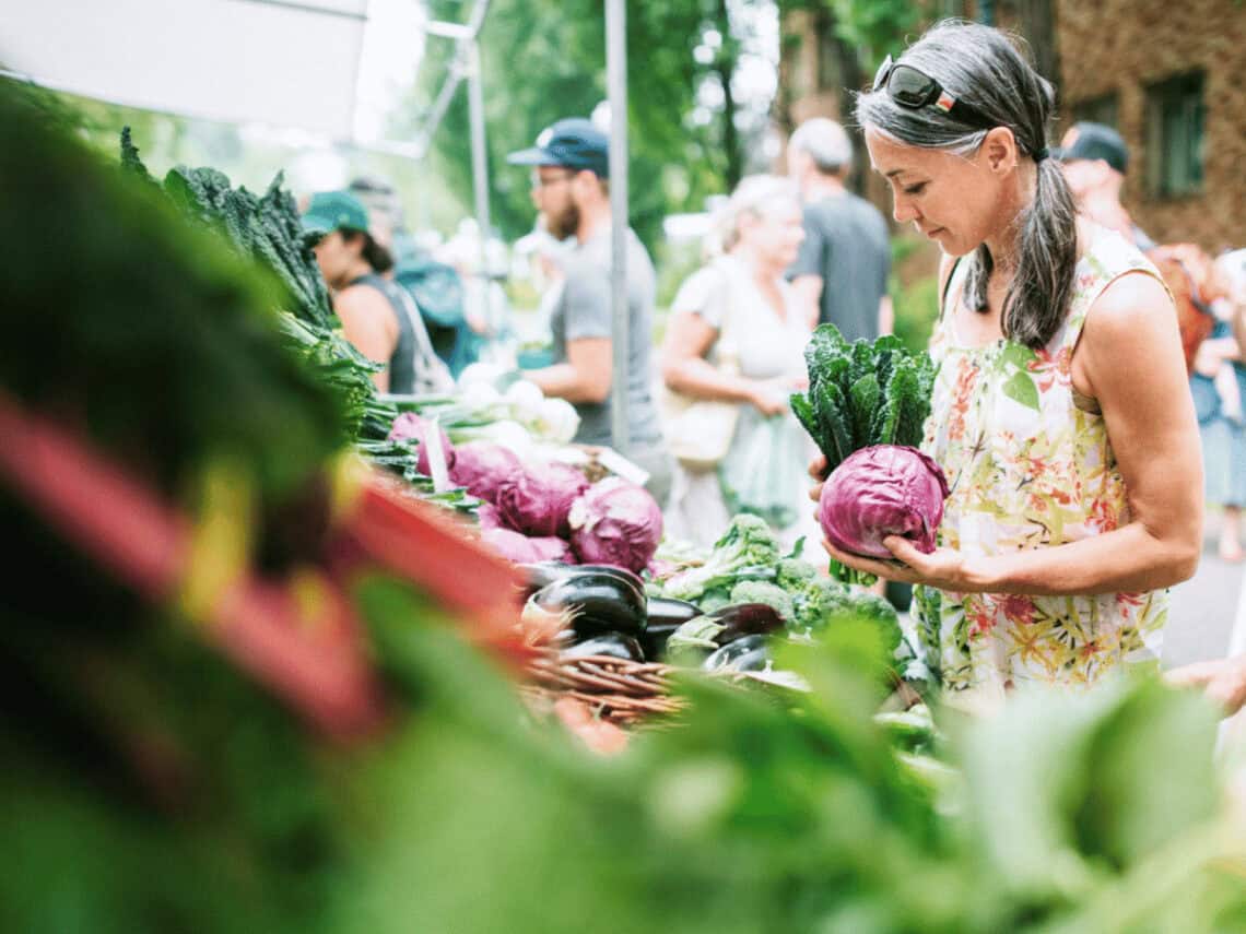 Eine Frau auf dem Bauernmarkt einkauft. Zum Thema: Was heißt regional einkaufen eigentlich?