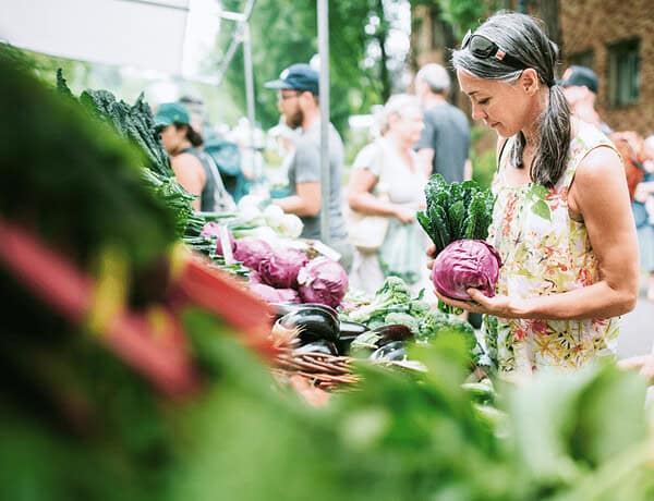 Eine Frau auf dem Bauernmarkt einkauft. Zum Thema: Was heißt regional einkaufen eigentlich?