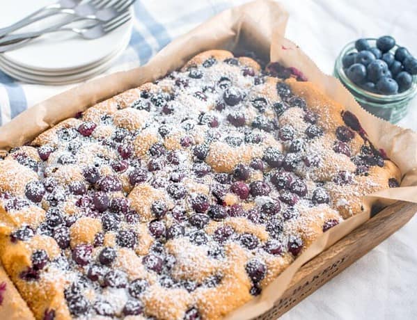 Auf dem Bild ist der Low Carb Blaubeer-Kuchen aus dem Rezept zu sehen. Im Hintergrund liegen Blaubeeren.