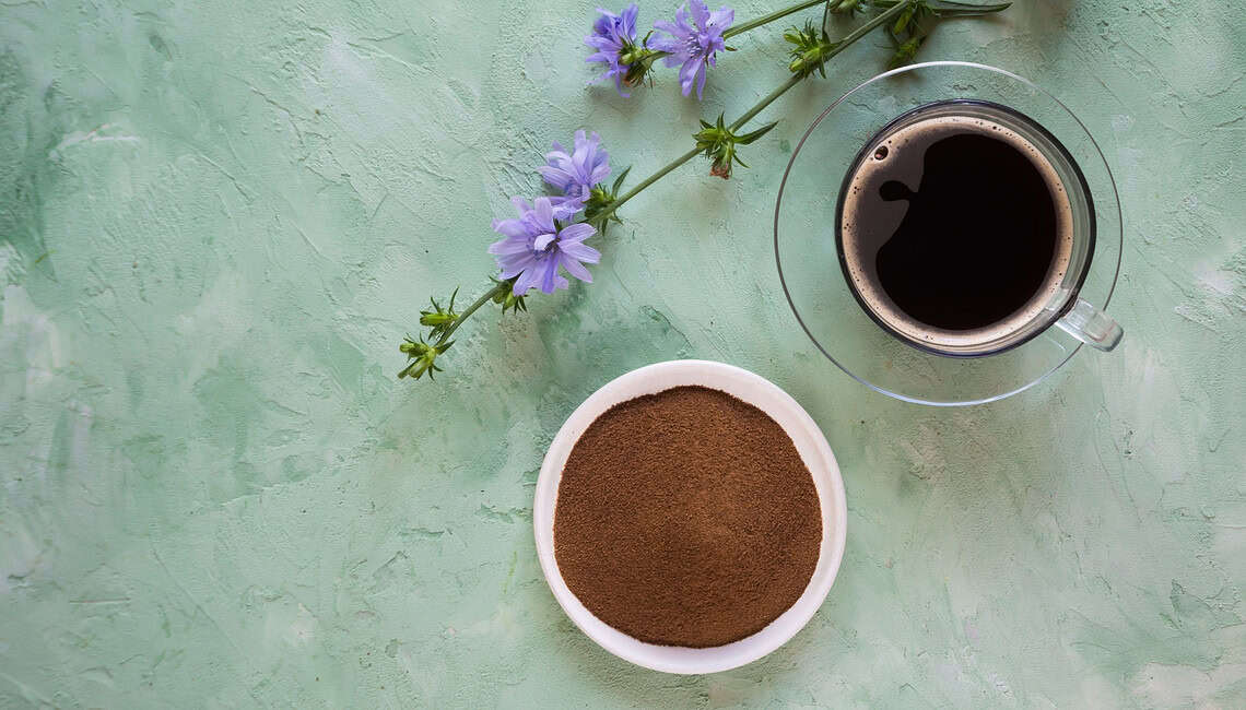 Kaffeealternative Zichorienkaffee: Auf dem Bild siehst Du eine Tasse Zichorienkaffee, ein Schälchen Pulver und eine Blüte der Wegwarte.