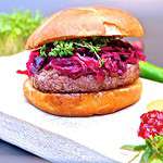 Glutenfreier Lamm Burger Preiselbeeren und Kräutern auf einem weißen Untergrund.