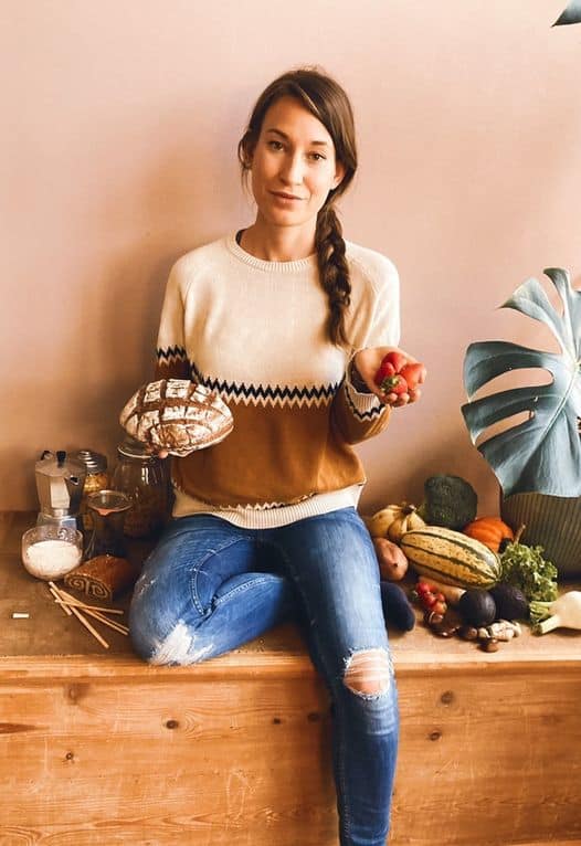 Im Bild ist Lisa, die glutenfrei isst. In der Hand hält sie Brot und Gemüse.