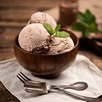 Drei Kugeln histaminarmes, veganes Mandeleis in einer braunen Holzschale.