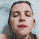 Frau, die ein eiskaltes Gesichtsbad nimmt, von unten fotografiert.